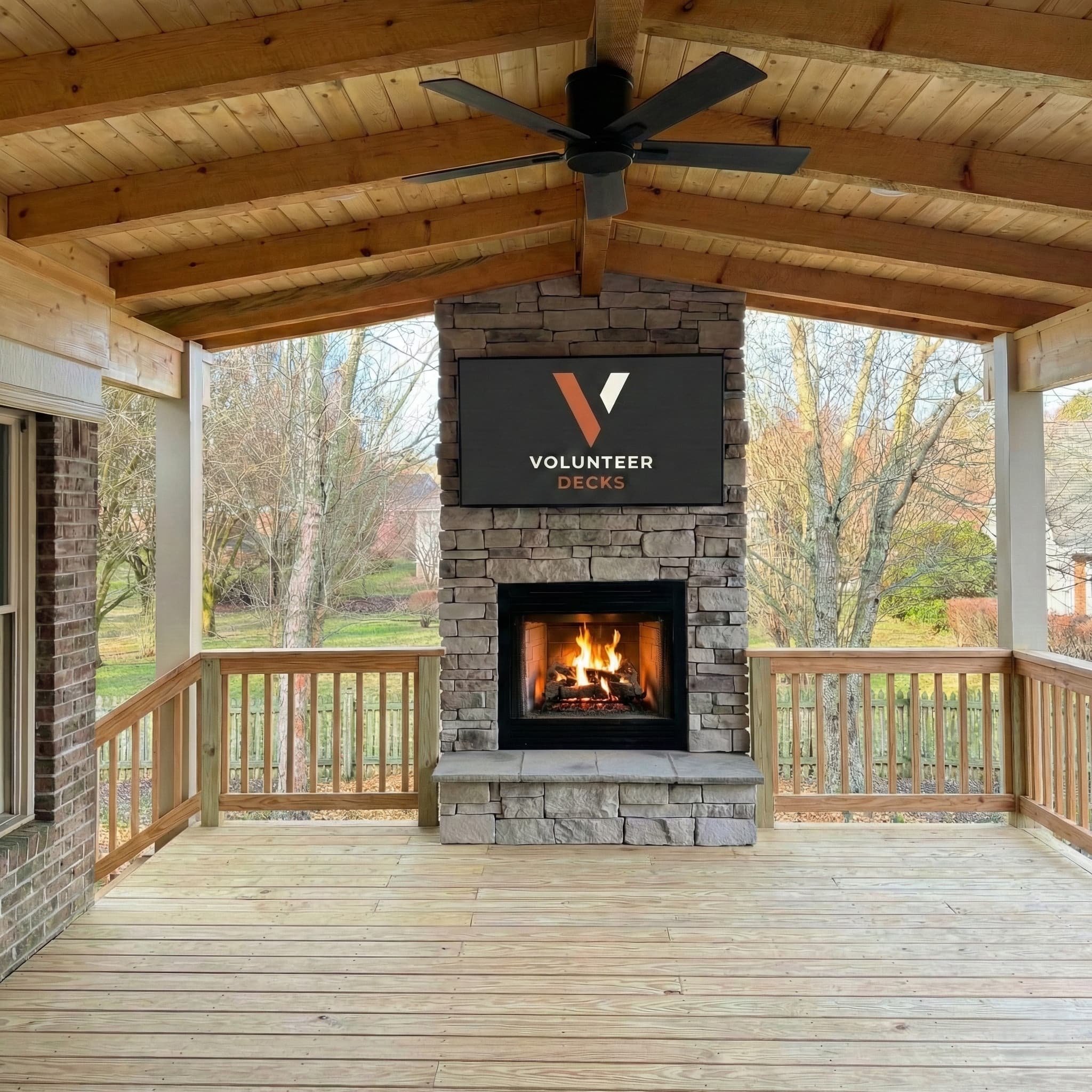 Covered deck with stone fireplace and vaulted wood ceiling
