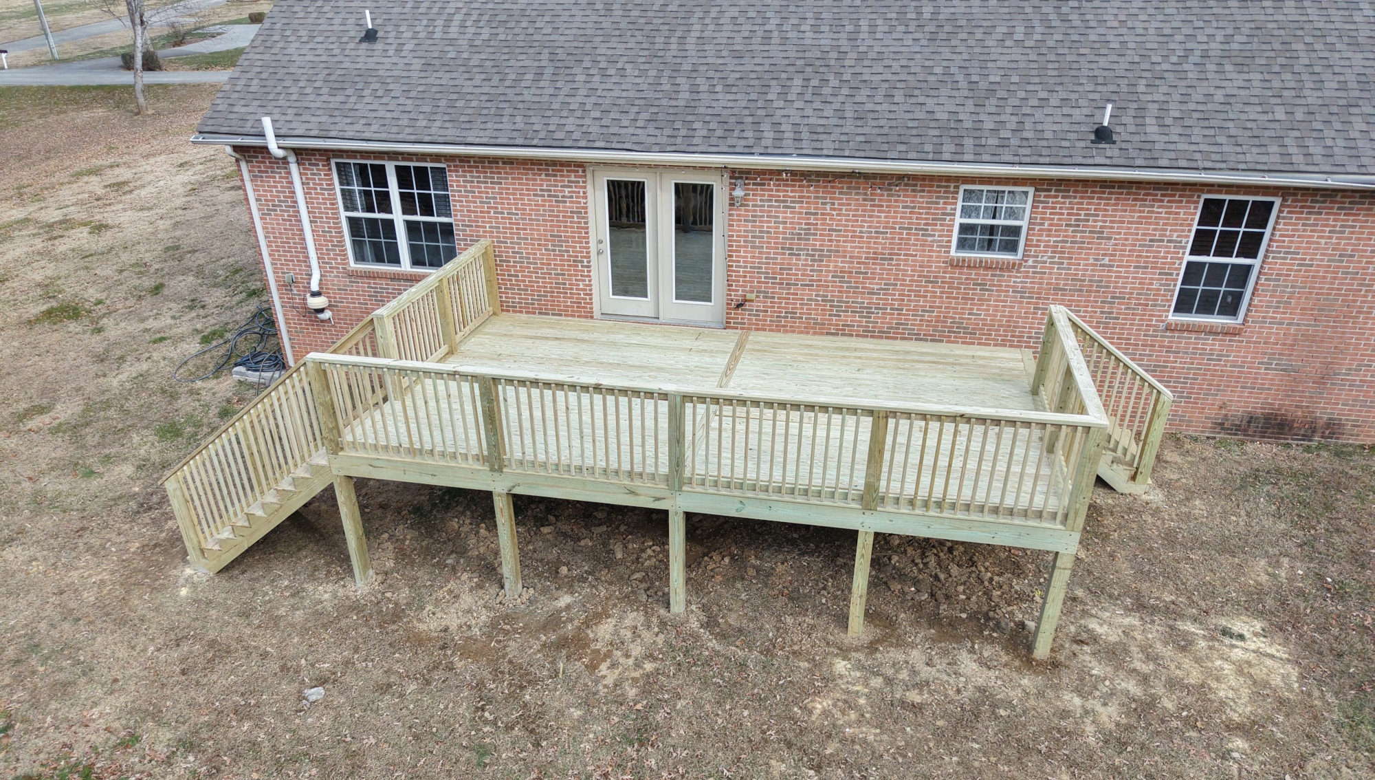 Elevated pressure-treated wood deck on a brick ranch home