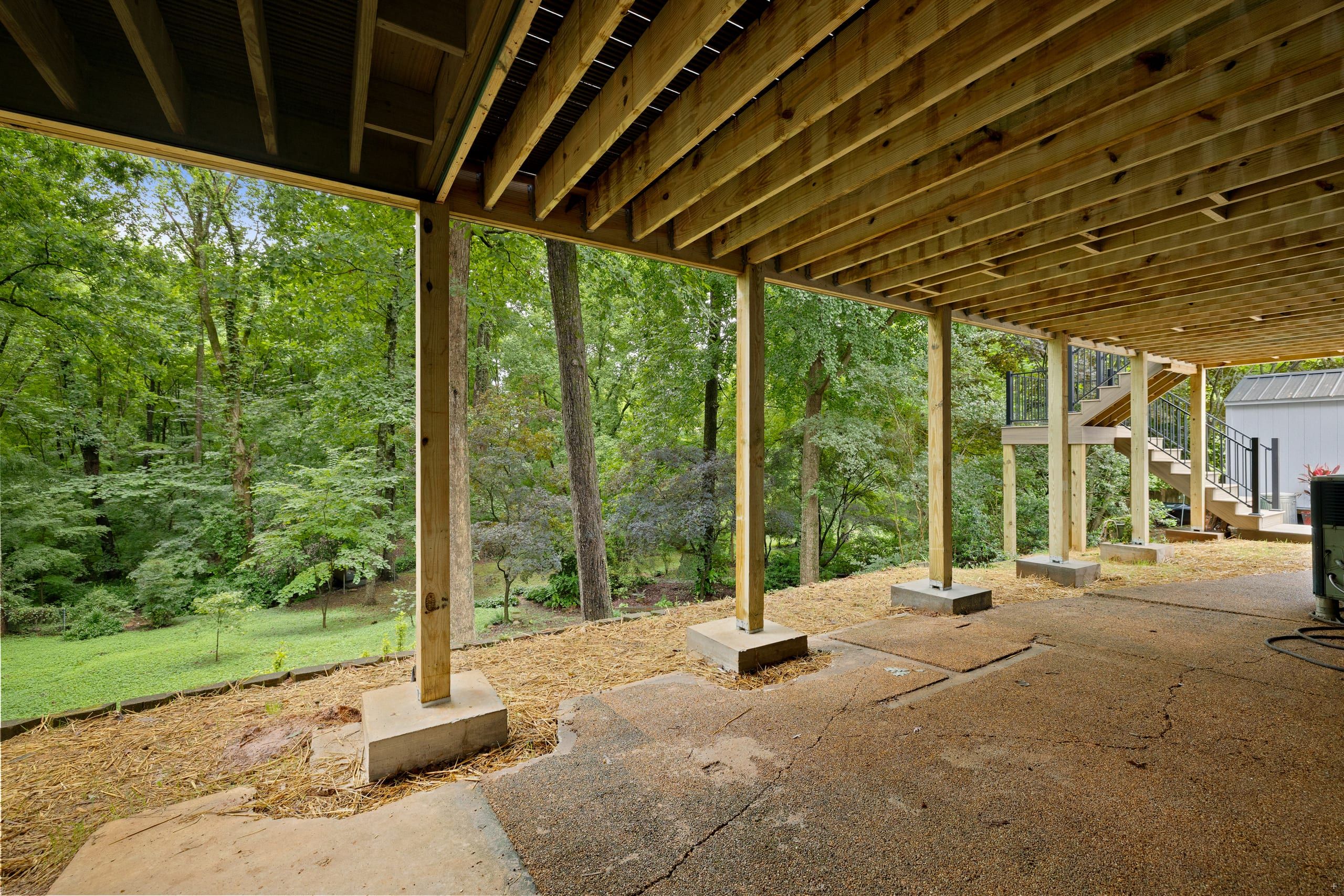 Under the Venice deck showing engineered pressure-treated posts on concrete footings and open framing over a walk-out patio